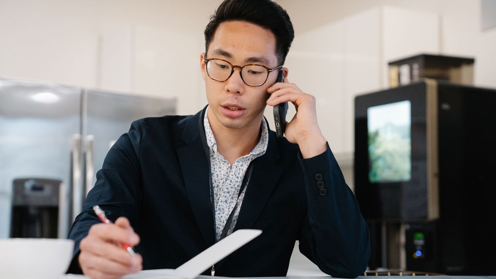 Une personne prend des notes pendant un appel téléphonique