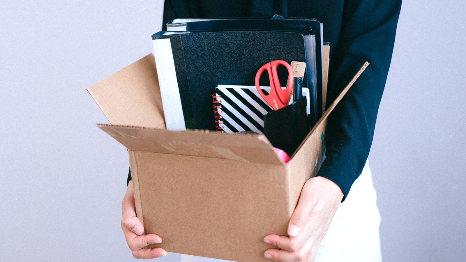 Un carton rempli de fournitures de bureau